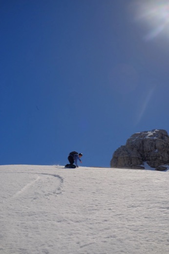 Teun snowboarding down a powder slope under a blue sky