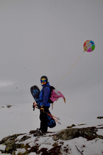 Teun on a snowy mountain with his splitboard and a birthday balloon